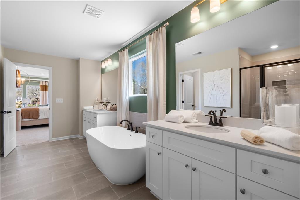 420 Hartsfield Road McDonough, GA 30252 - Photo 43 of 45 a bathroom with a double vanity sink a mirror and a bathtub