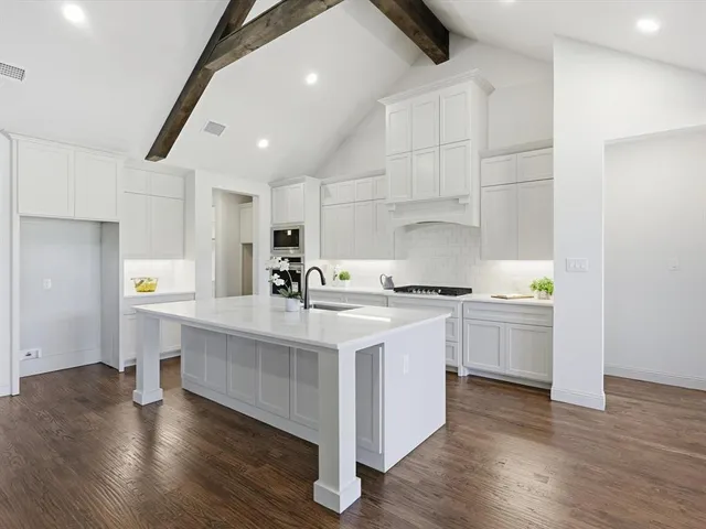 a kitchen with a sink cabinets and wooden floor