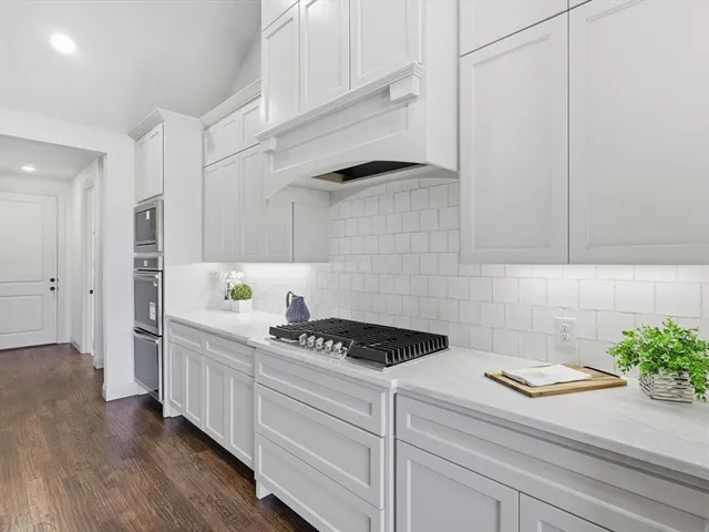 a kitchen with white cabinets and a stove