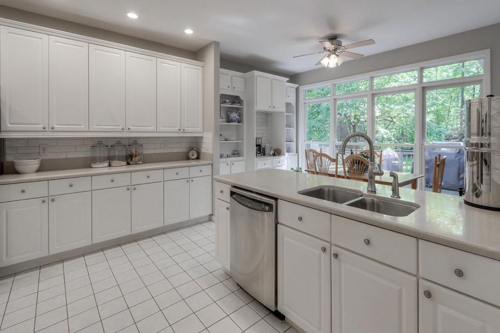 Chef's kitchen is home to a new designer tile backsplash, eat in kitchen, breakfast bar, coffee bar, pantry, gas cooktop with wall of windows overlooking the private fenced backyard.