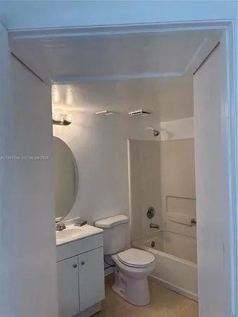 a bathroom with a granite countertop toilet a sink and a mirror