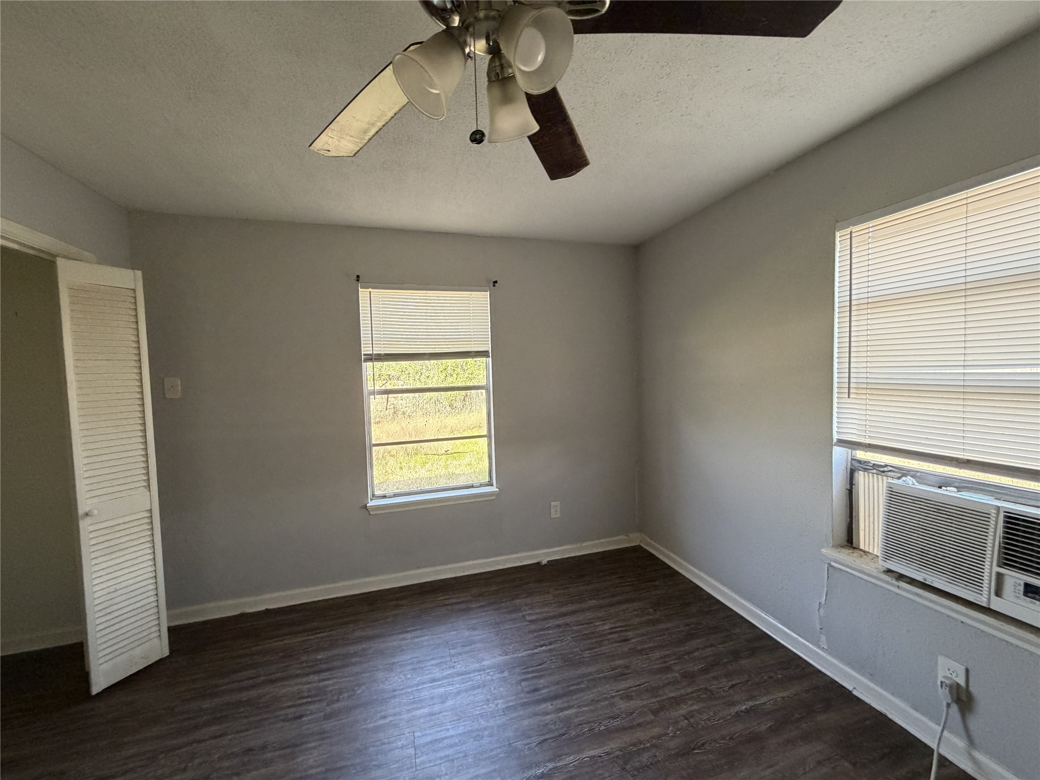 2409 Hodges Street Baytown, TX 77521 - Photo 16 of 29 an empty room with wooden floor chandelier fan and windows