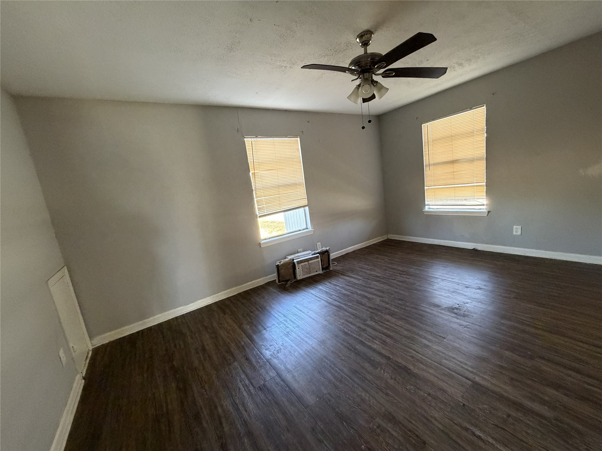 2409 Hodges Street Baytown, TX 77521 - Photo 17 of 29 an empty room with wooden floor chandelier fan and windows
