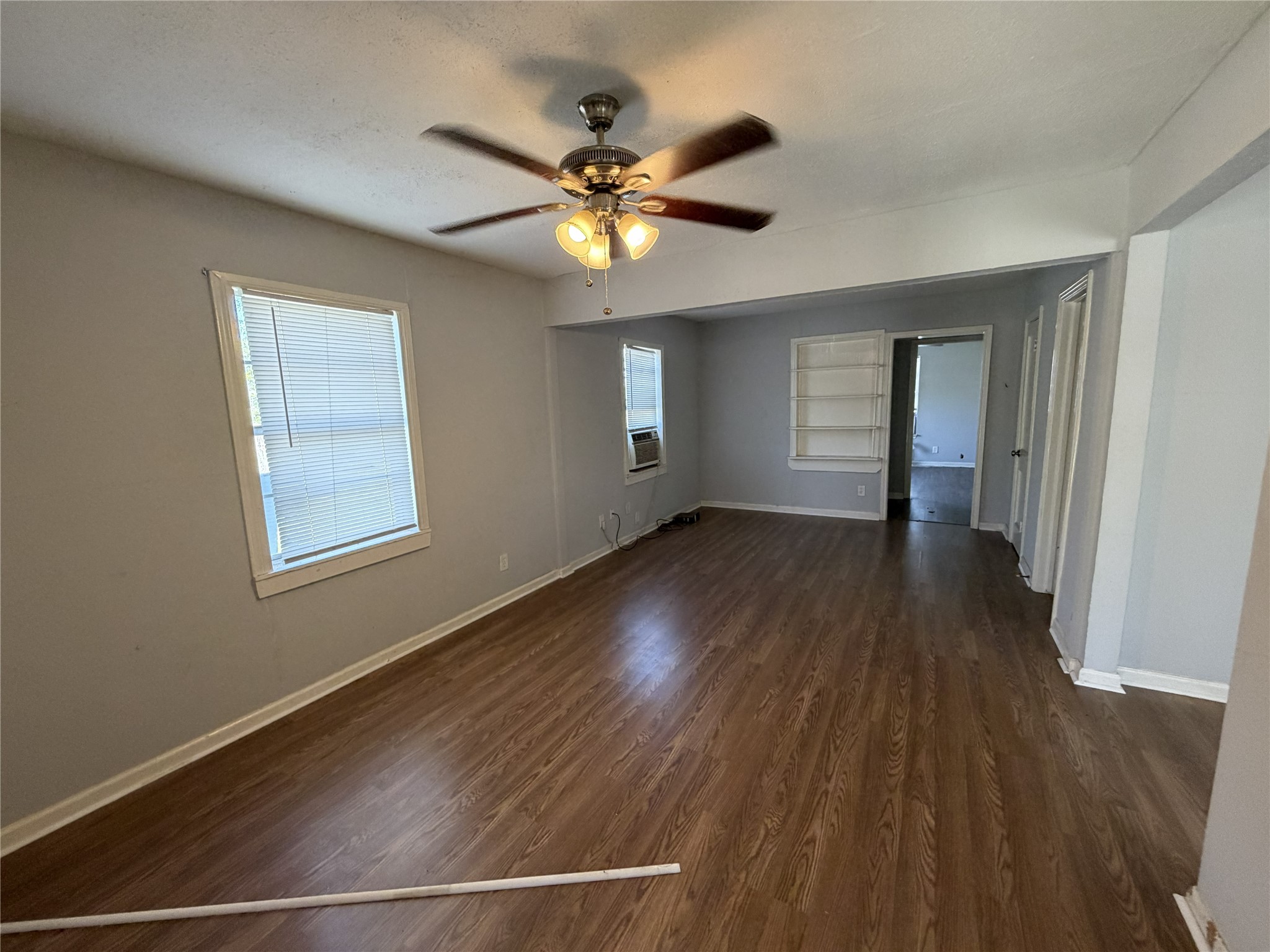 2409 Hodges Street Baytown, TX 77521 - Photo 4 of 29 a view of an empty room with wooden floor and a window