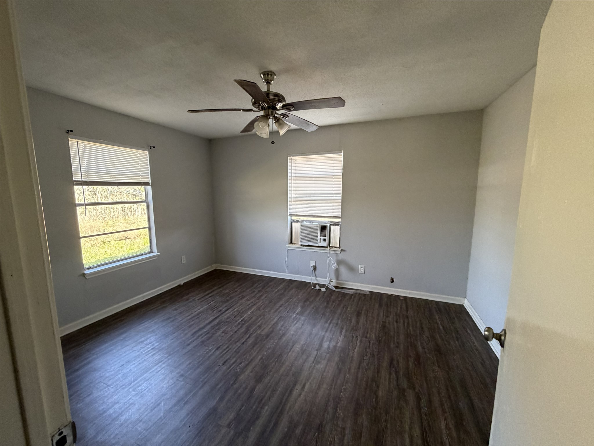 2409 Hodges Street Baytown, TX 77521 - Photo 8 of 29 an empty room with wooden floor ceiling fan and windows