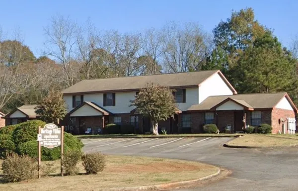 a front view of a house with a yard and trees