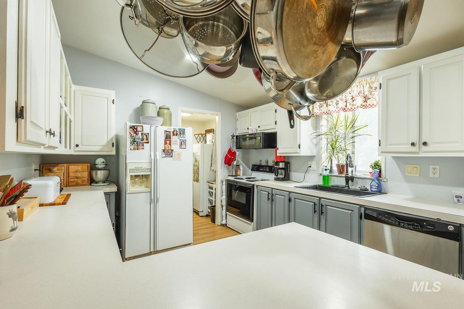 10 Reseda Ridge Circle Garden Valley, ID 83622 - Photo 13 of 28 Kitchen with white appliances, light countertops, white cabinetry, and vaulted ceiling
