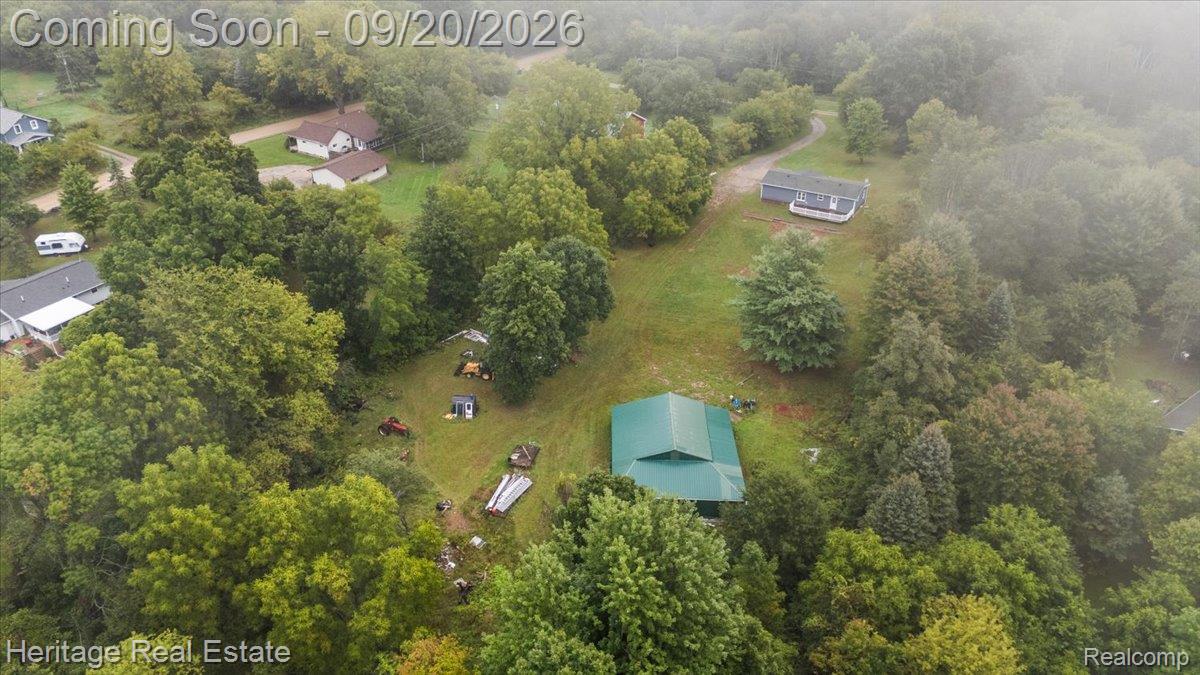 3337 Le Valley Road Columbiaville, MI 48421 - Photo 47 of 57 Expansive treed lot featuring a primary residence, secondary dwelling, and outbuilding with a green metal roof