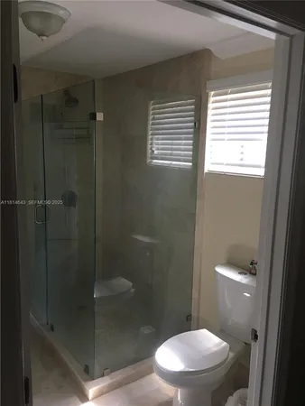 a bathroom with a toilet and a shower