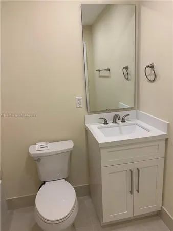 a white toilet sitting next to a bathroom sink