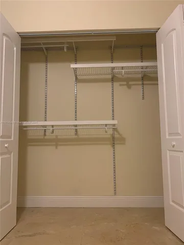 a view of a hallway with wooden cabinets