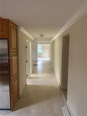 a view of a hallway with wooden cabinets