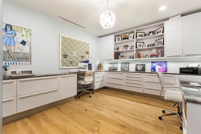 a room with a flat screen tv and a ceiling fan