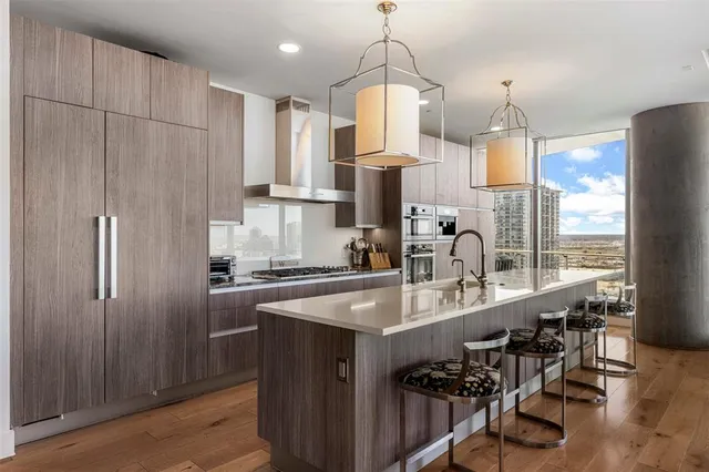 a kitchen with kitchen island granite countertop a sink a center island stainless steel appliances and cabinets