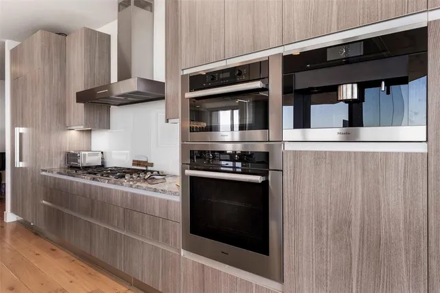 a kitchen with stainless steel appliances granite countertop a stove and a refrigerator