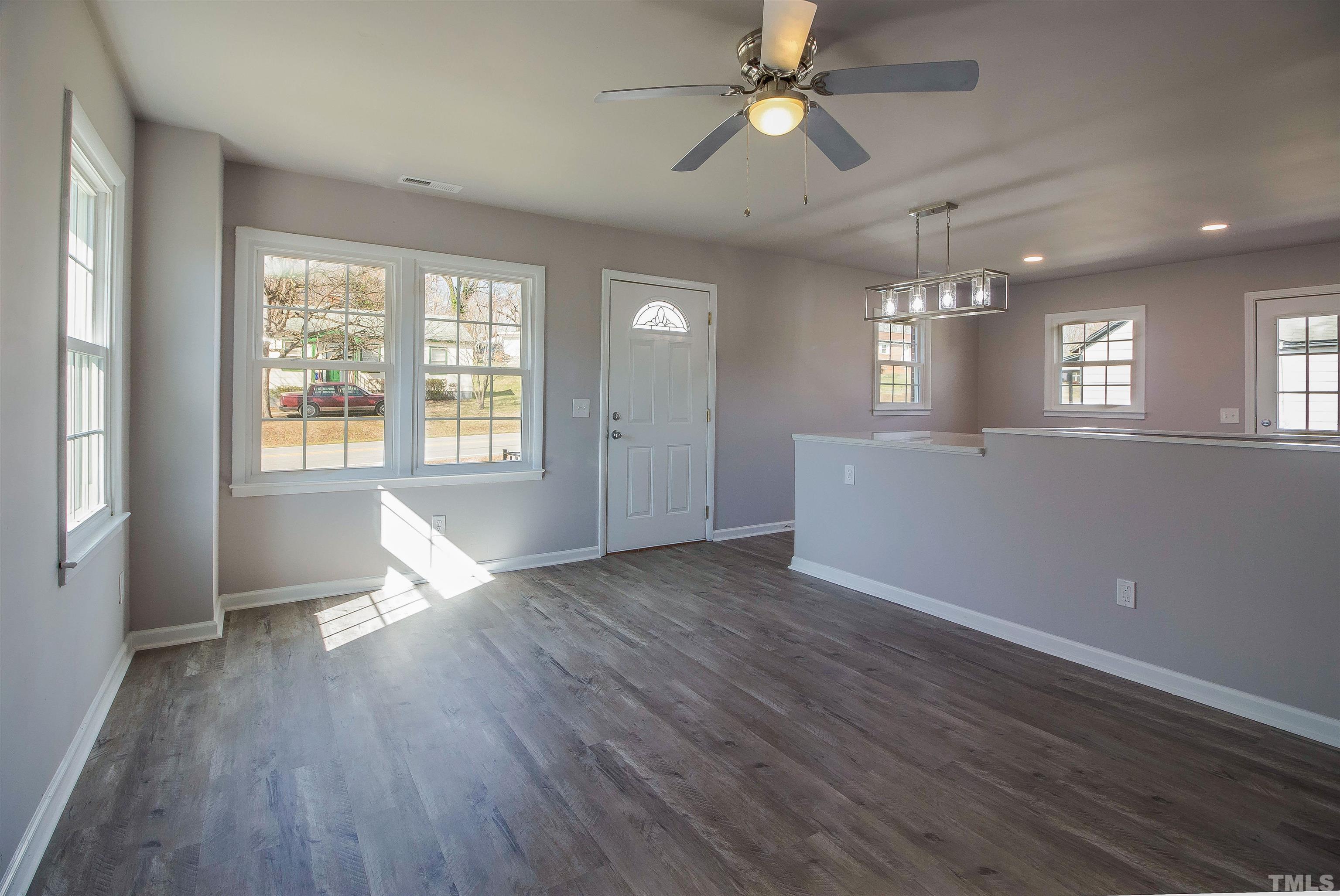 430 South Foushee Street Roxboro, NC 27573 - Photo 8 of 32 a view of an empty room with wooden floor and a window