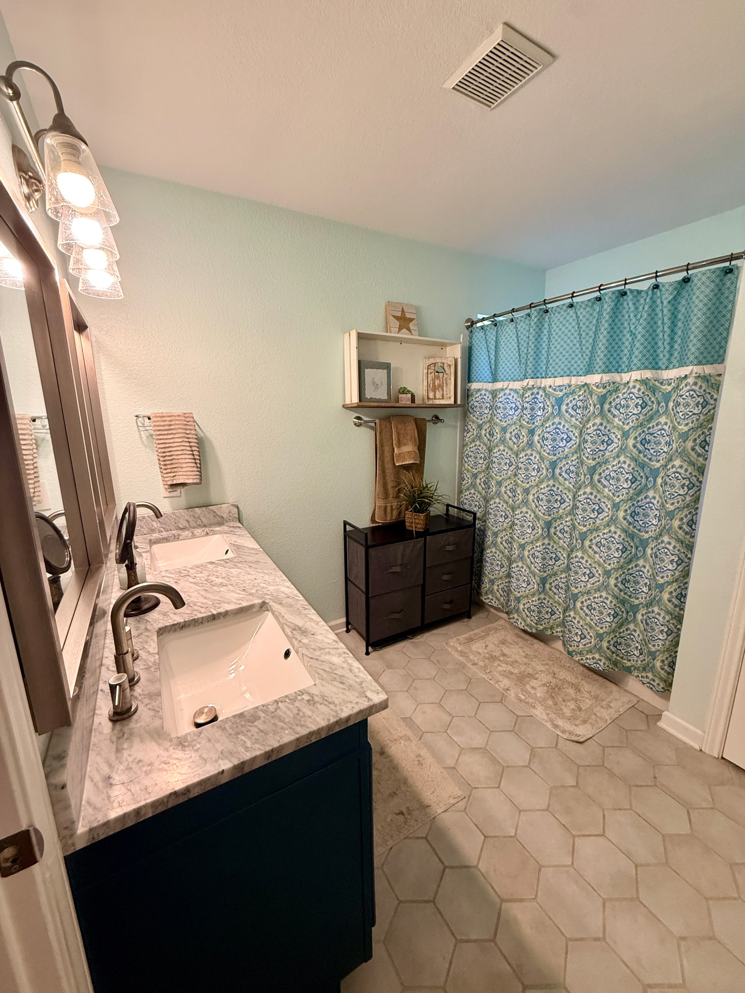 904 Double File Cove Round Rock, TX 78665 - Photo 21 of 25 A spacious double vanity anchors this updated bathroom with hexagonal tile flooring.