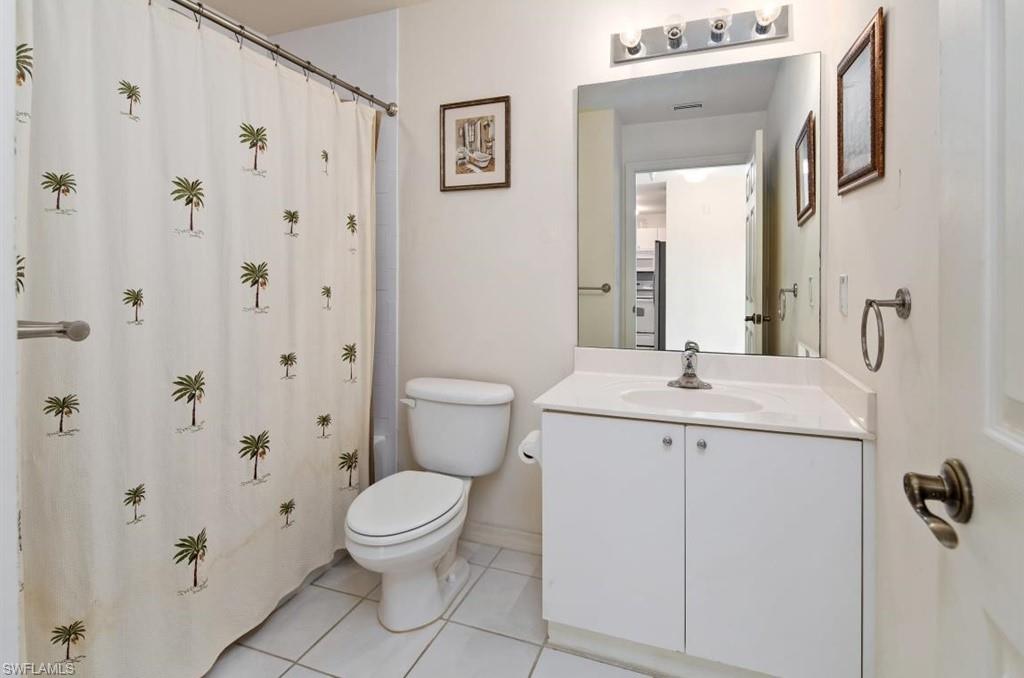 4510 Botanical Pl Circle, Unit 402 Naples, FL 34112 - Photo 14 of 15 a bathroom with a sink a toilet and a mirror