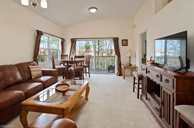 a living room with furniture flat screen tv and a large window