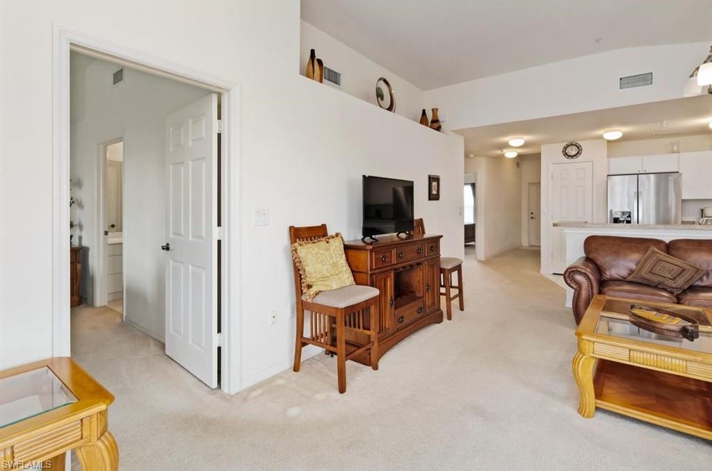 4510 Botanical Pl Circle, Unit 402 Naples, FL 34112 - Photo 5 of 15 a living room with furniture and a flat screen tv
