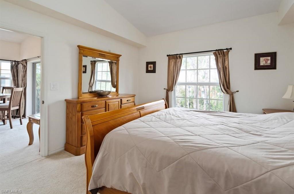 4510 Botanical Pl Circle, Unit 402 Naples, FL 34112 - Photo 8 of 15 a bedroom with a bed and a dresser next to a window