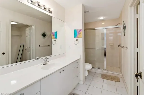 a bathroom with a double vanity sink toilet and shower