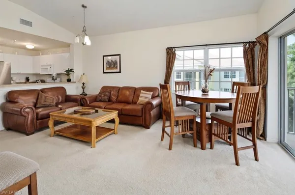 a living room with furniture a large window and a flat screen tv