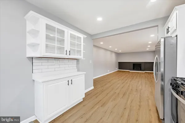 a open kitchen with a sink and wooden floor