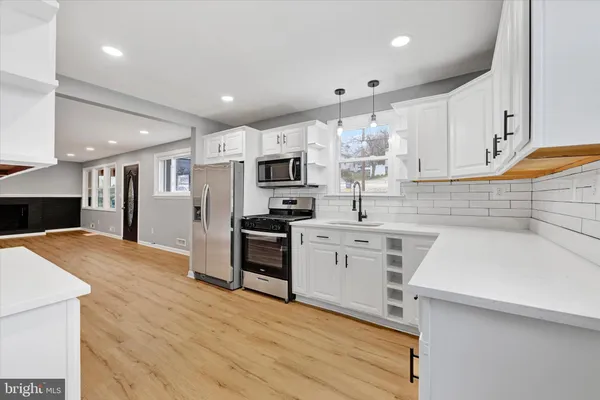 a kitchen with kitchen island a sink stainless steel appliances and cabinets