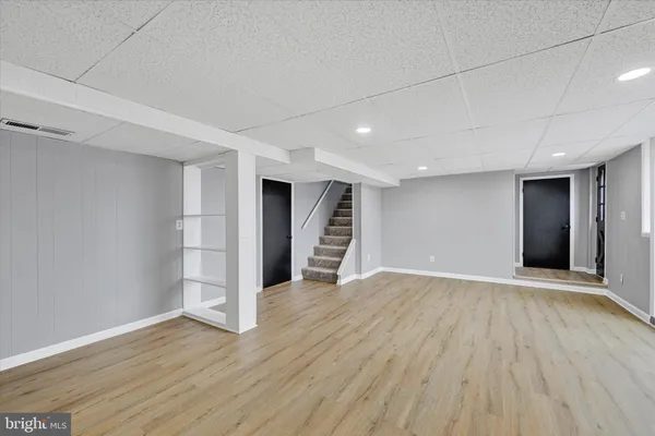 a view of an empty room with wooden floor and closet