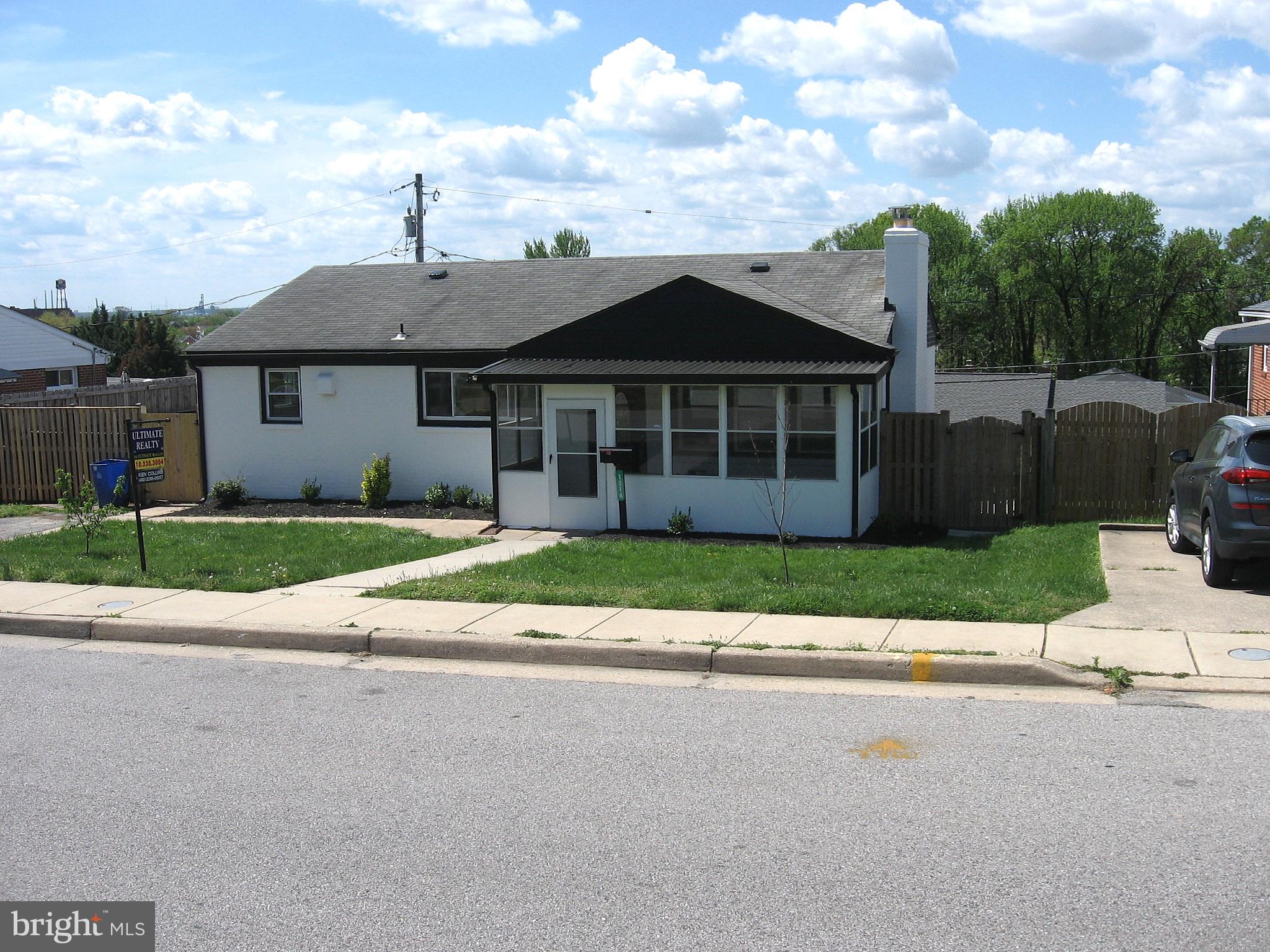 1214 South 48th Street Baltimore, MD 21222 - Photo 2 of 38 a view of a house with a yard and large trees