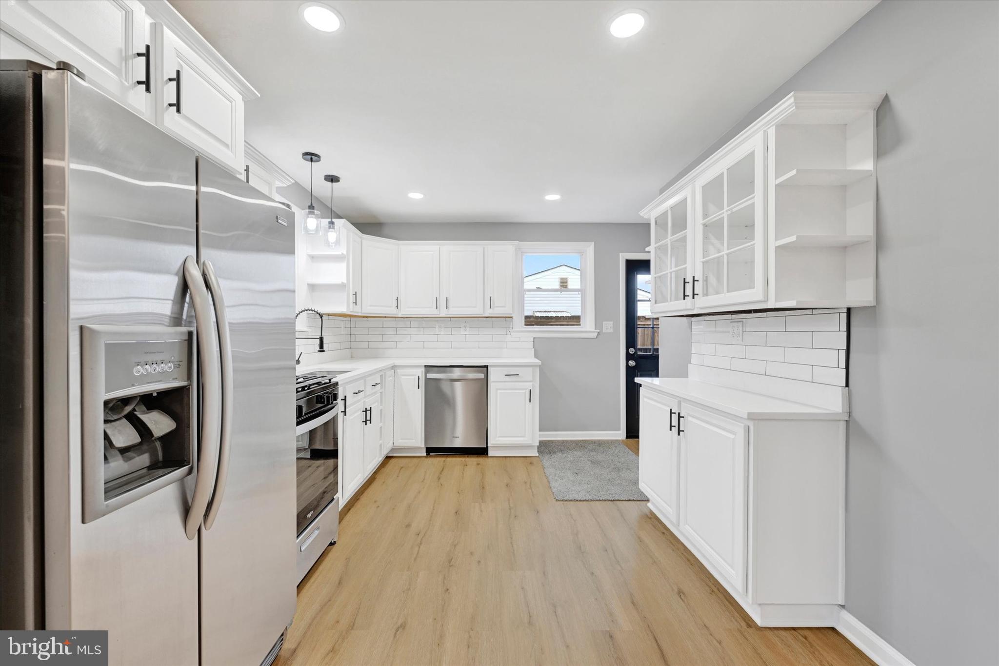 1214 South 48th Street Baltimore, MD 21222 - Photo 25 of 38 a kitchen with stainless steel appliances a refrigerator a stove top oven and white walls