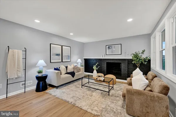 a living room with stainless steel appliances kitchen island granite countertop furniture a wooden floor and a sink