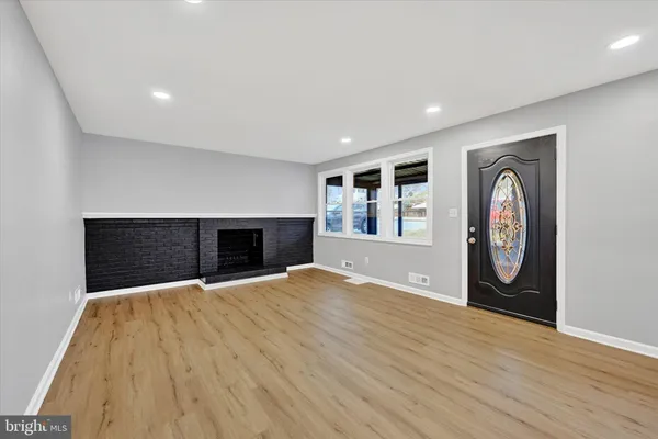 a view of an empty room with a fireplace and a window