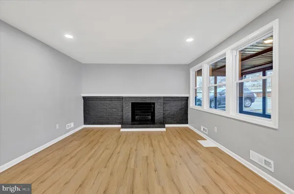 a view of an empty room with a fireplace and a window