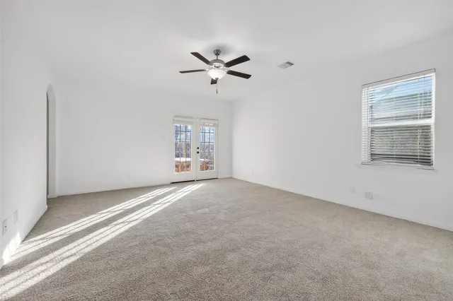 a view of a livingroom with a ceiling fan and kitchen view