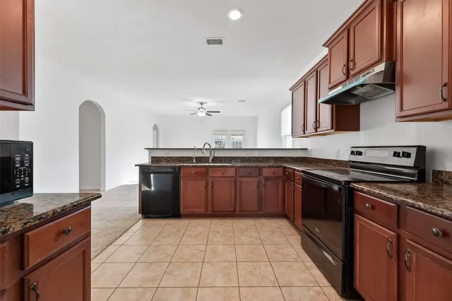 a kitchen with stainless steel appliances granite countertop a sink stove and cabinets