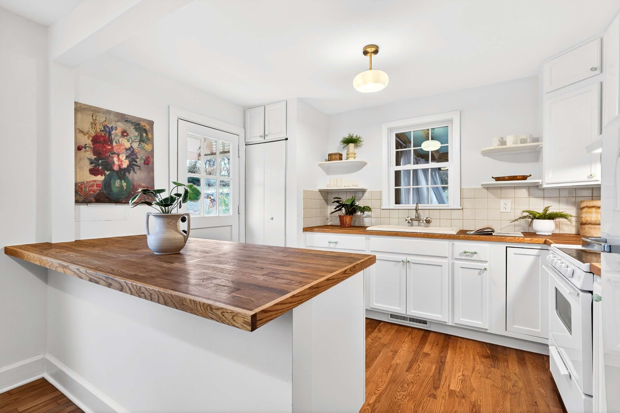 2017 Hackberry Lane Nashville, TN 37206 - Photo 11 of 36 a view of kitchen island a sink wooden floor dining table and chairs