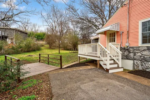 a view of a house with backyard and a trees