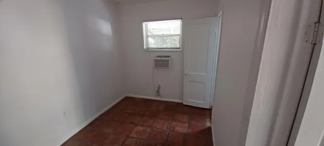 a view of a small space with wooden floor and a window