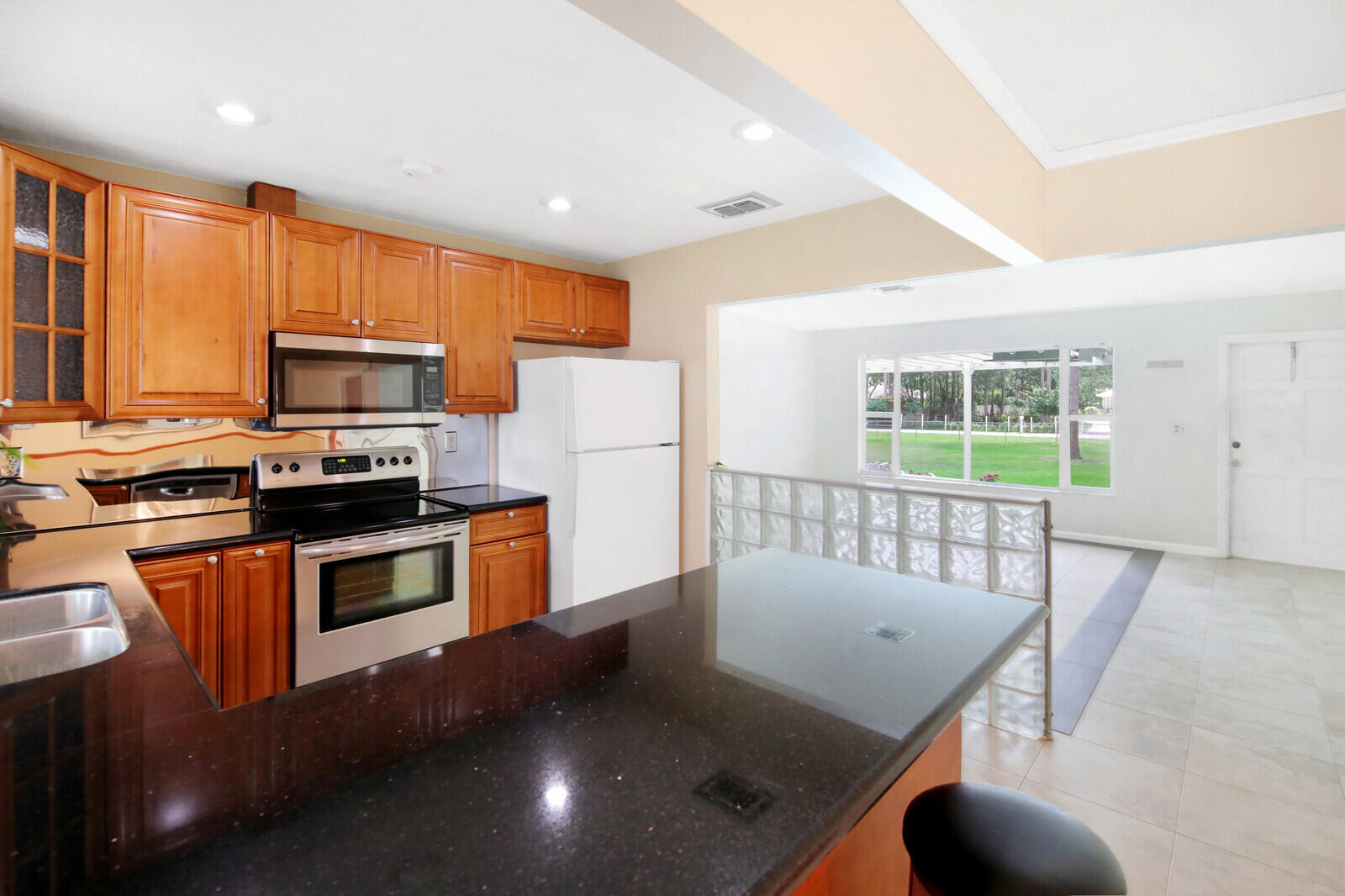 17575 Bridle Court Jupiter, FL 33478 - Photo 15 of 35 a kitchen with stainless steel appliances granite countertop a stove a refrigerator a microwave oven with a dining table and chairs