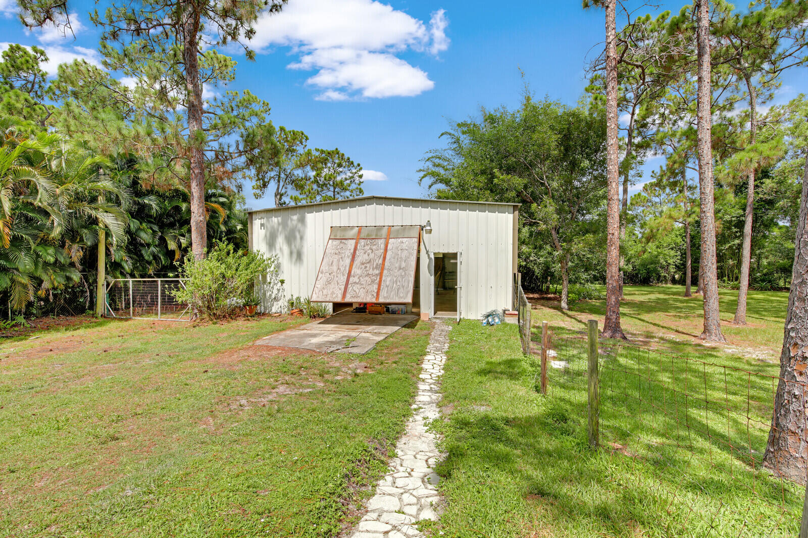 17575 Bridle Court Jupiter, FL 33478 - Photo 30 of 35 a view of a backyard with table and chairs and potted plants and large tree