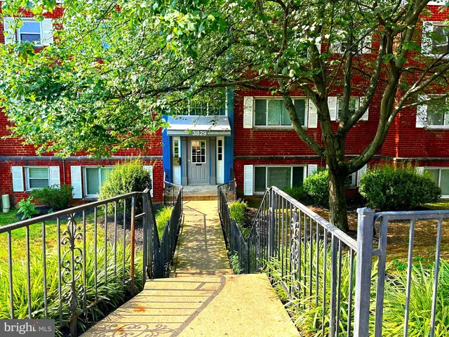 a view of a house with wooden fence next to a yard