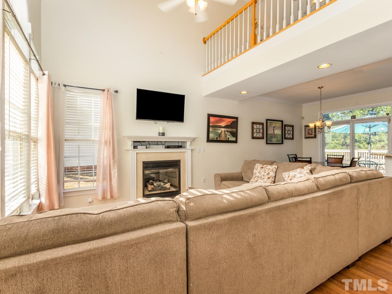 79 Kerrylane Drive Angier, NC 27501 - Photo 11 of 30 a living room with furniture a flat screen tv and a fireplace