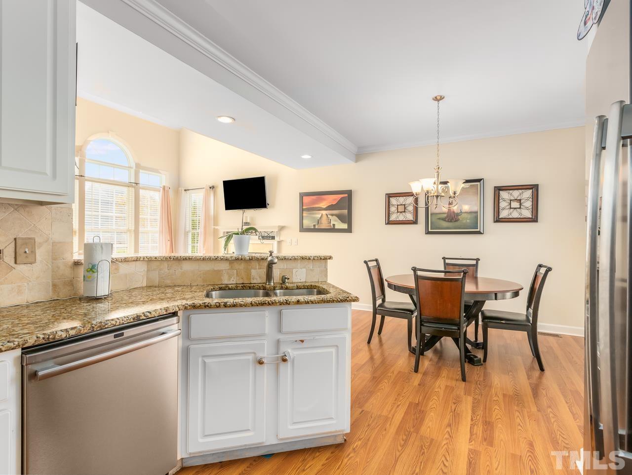 79 Kerrylane Drive Angier, NC 27501 - Photo 16 of 30 a kitchen with stainless steel appliances granite countertop a sink a stove a table and chairs