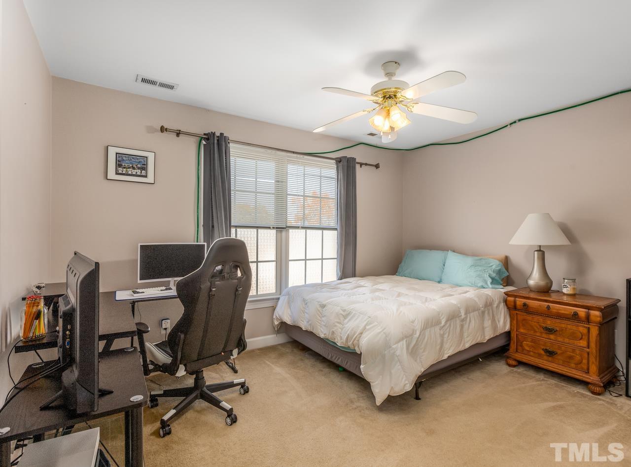 79 Kerrylane Drive Angier, NC 27501 - Photo 25 of 30 a bedroom with a bed a desk chair and a chandelier