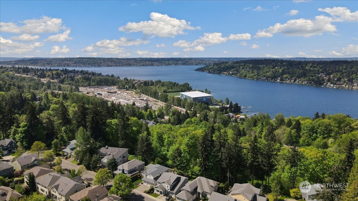 an aerial view of a house with a yard and lake view in back