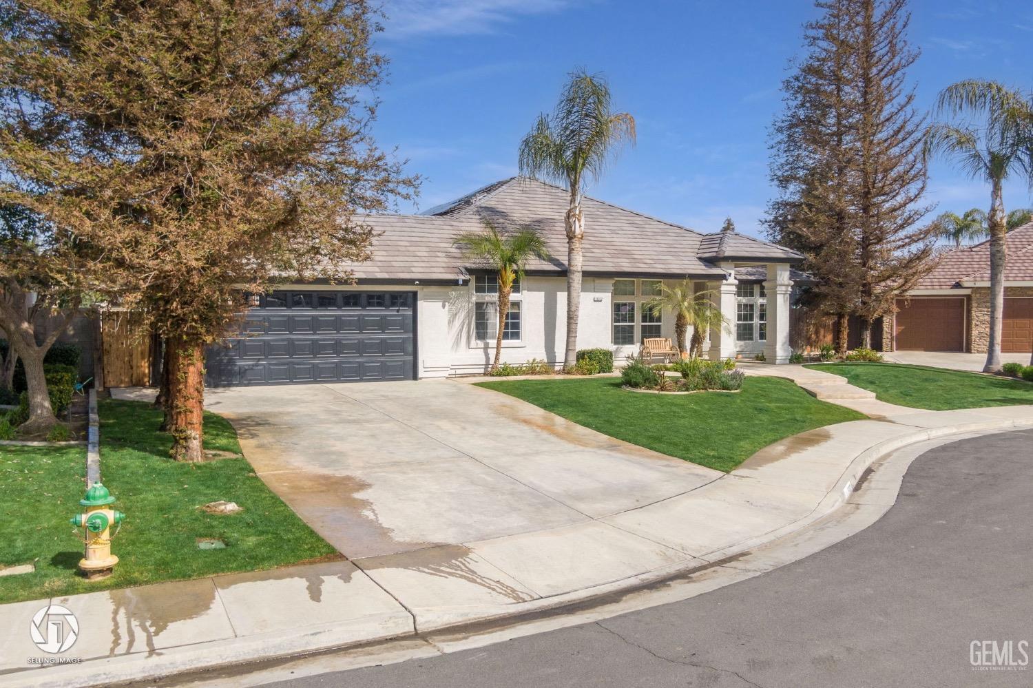 Undisclosed Address Bakersfield, CA 93314 - Photo 2 of 45 a front view of a house with a yard and potted plants