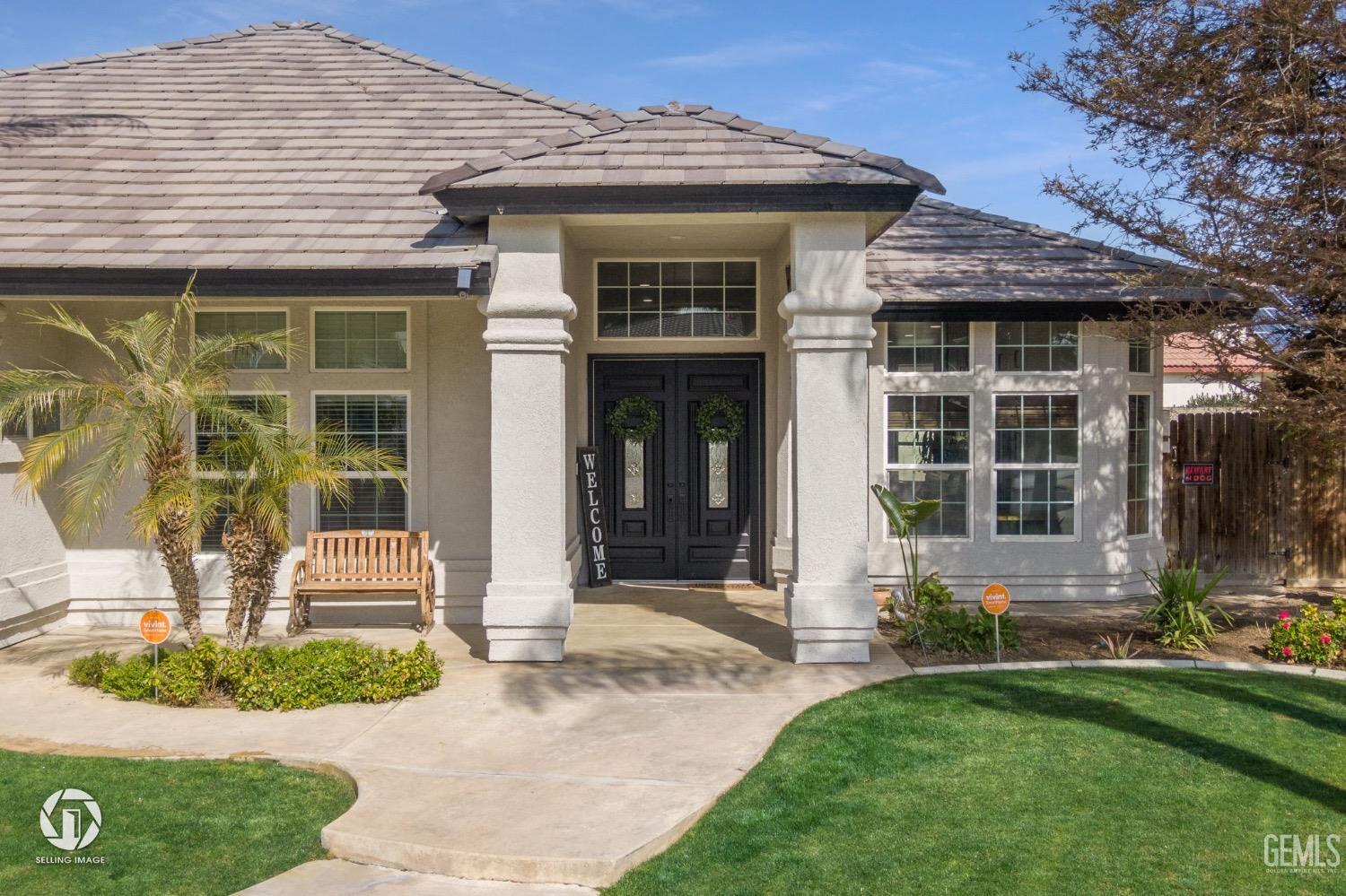 Undisclosed Address Bakersfield, CA 93314 - Photo 4 of 45 a front view of a house with a yard and potted plants
