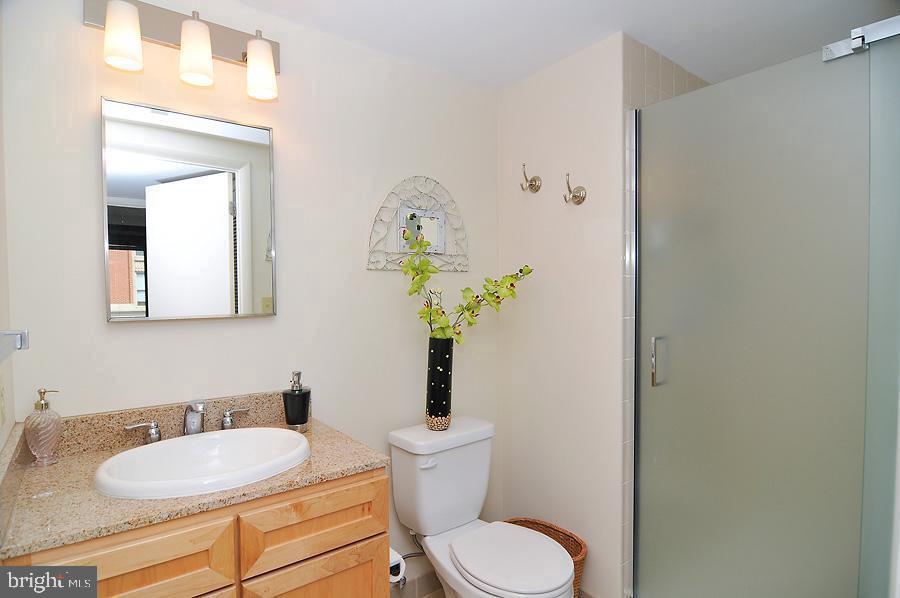 1150 K Street Northwest, Unit 1305 Washington, DC 20005 - Photo 5 of 18 a bathroom with a granite countertop toilet sink and mirror
